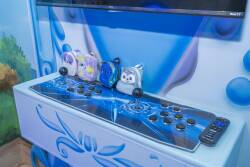 Discover a lively gaming corner with a sleek arcade console and colorful designs, perfect for all ages. Bright blue tones and playful decor create an inviting atmosphere for fun and relaxation.