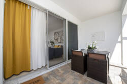 Enjoy a cozy nook with a stylish wooden table and sleek chairs, ideal for morning coffee or evening chats. Bright yellow curtains bring cheer, and the natural light creates a warm atmosphere you'll love.