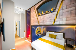 Experience a fun atmosphere with vibrant Minion-themed decor that sets the tone for your stay. The cozy bed, dressed in a crisp white duvet and cheerful yellow throw, is complemented by warm lighting for a welcoming glow.