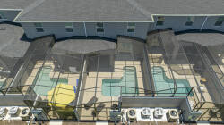 Discover a vibrant outdoor oasis featuring sparkling pools surrounded by stylish screen enclosures, perfect for soaking up the sun. The inviting outdoor space is complemented by a cheerful yellow cabana, offering a playful touch.