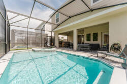 Step outside to enjoy your own private oasis featuring a sparkling pool, surrounded by elegant lounging chairs and a shaded patio area. The spacious screened enclosure invites you to relax while soaking up the sunshine in comfort.