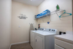 Experience the convenience of a well-equipped laundry room featuring modern appliances, ample shelving for supplies, and a tidy layout. The soft color palette and functional design make this an essential space for your stay.