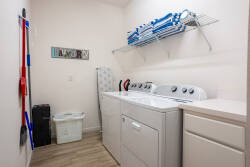 Enjoy our spacious laundry room with a modern washer and dryer, plus handy shelving for easy organization. The light walls and wood-like flooring create a bright, clean vibe, making your chores feel effortless and enjoyable.