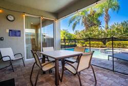 Step outside to your private patio, where a stylish dining set awaits under soft lighting, perfect for alfresco meals. Enjoy views of lush greenery and a sparkling pool, offering a refreshing backdrop for relaxation.