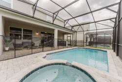 Unwind in your private oasis, featuring a sleek pool surrounded by elegant stone pavers. The screened enclosure invites natural light while providing a sense of seclusion, perfect for relaxing days and enchanting evenings.