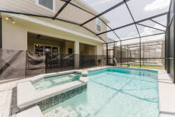 Step into your private oasis with a sparkling pool framed by a stylish screened enclosure, ensuring comfort and tranquility. The sleek tile work and inviting hot tub create the perfect backdrop for relaxation under the sun.