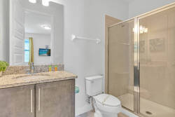 Freshen up in a bright bathroom with a granite vanity, large mirror, glass shower, soft neutral tones, and simple modern details, creating a clean and comfortable space.