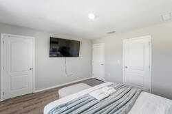 Rest in a bright bedroom with a cozy white bed, soft blue accents, fresh greenery, natural light, and simple décor, creating a calm and comfortable space for your vacation.