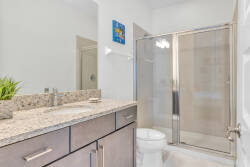 Experience a beautifully designed bathroom with a sleek glass shower and elegant granite countertop, creating a sophisticated and refreshing ambiance—ideal for unwinding after a day of adventure.