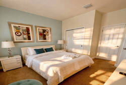 This cozy bedroom features soft neutral tones and plush carpeting for a warm ambiance. Stylish artwork and tasteful decor add a personal touch, while the inviting bed with crisp linens promises restful nights for our guests.